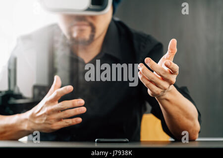 businessman wearing virtual reality goggles in modern office with mobile phone using with VR headset Stock Photo