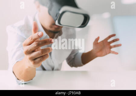 businessman wearing virtual reality goggles in modern office with mobile phone using with VR headset Stock Photo