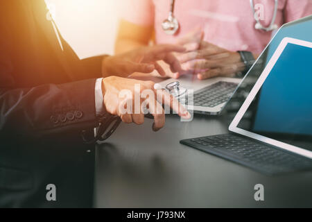 Medical co working concept,Doctor working with smart phone and digital tablet and laptop computer to meeting his team in modern office at hospital Stock Photo