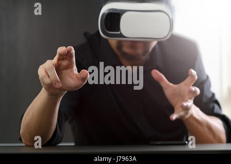 businessman wearing virtual reality goggles in modern office with Smartphone using with VR headset Stock Photo