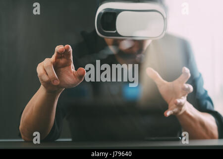 businessman wearing virtual reality goggles in modern office with Smartphone using with VR headset Stock Photo