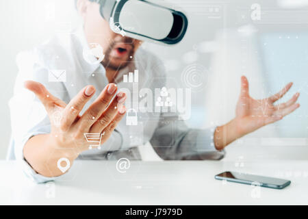businessman wearing virtual reality goggles in modern office with mobile phone using with VR headset with screen icon diagram Stock Photo