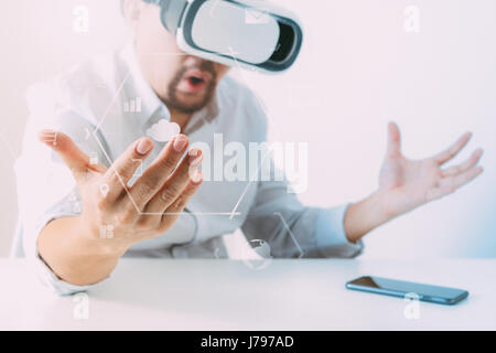 businessman wearing virtual reality goggles in modern office with mobile phone using with VR headset with screen icon diagram Stock Photo