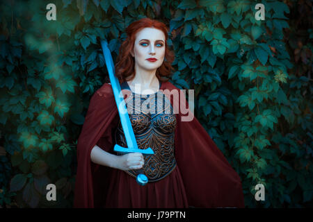 Woman warrior with sword wearing a cuirass. On the shoulders of her cloak. Stock Photo