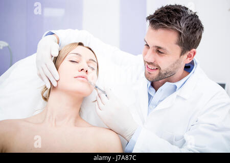 Aesthetic surgery, woman receiving injection into lip Stock Photo