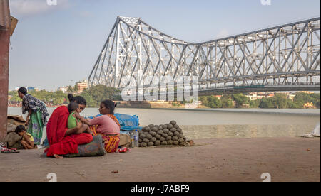 Happiness in poverty. A mother caresses her baby girl child at the Hooghly river banks near Howrah bridge at Kolkata, India. Stock Photo