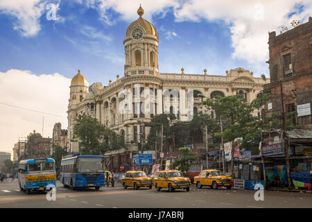 City traffic with public buses and taxi in front of vintage Metropolitan building at Esplanade the busiest city road intersections of Kolkata. India. Stock Photo