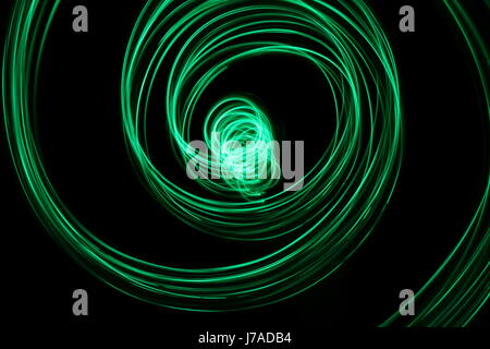 Green Light Painting Photography - swirls and loops against a black background Stock Photo
