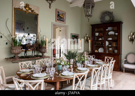 Spacious dining area. The eighteenth-century mahogany table is laid with crystal and block-printed linen napkins. The chairs are antique from France a Stock Photo