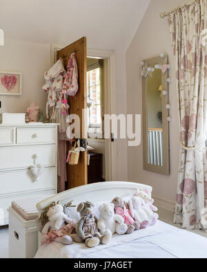 Assorted teddy bears on bed in childs bedroom, the chest of drawers is painted in Farrow & Ball's Pointing by Fairlily Stock Photo