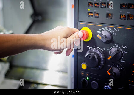 A Tumb ready to press emergency Stop button on Control panel of CNC machine ;Intermarch 2017 Industrial Machinery Exhibition at Bitech Thailand 20 Apr Stock Photo