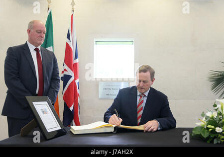 Irish Taoiseach Enda Kenny, with Deputy Head of Mission Neil Holland (left), signs a book of condolence at the British Embassy in Dublin for those affected by the attack in Manchester. Stock Photo