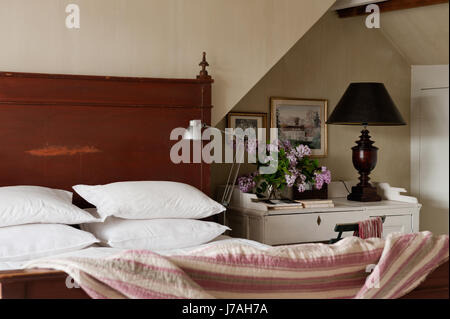 Pillows stacked on 18th century Italian wooden bedstead Stock Photo