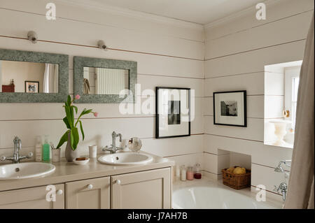 Double basin and mirrors with cut tulips on vanity unit Stock Photo