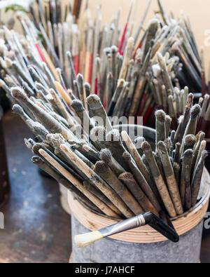 Artists paint brushes stored in jars Stock Photo