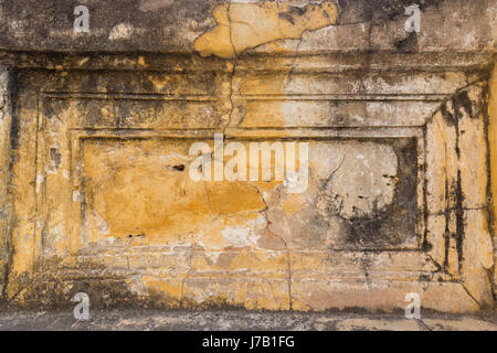 Damaged, old and plaster peeled off of a orange wall. Stock Photo