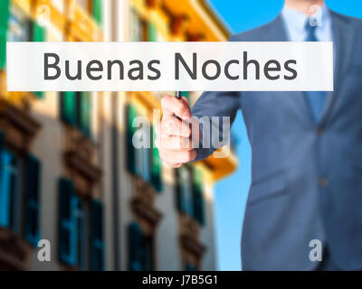 Buenas Noches (Good Night In Spanish) - Businessman hand holding sign. Business, technology, internet concept. Stock Photo Stock Photo