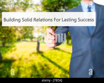 Building Solid Relations For Lasting Success - Business man showing sign. Business, technology, internet concept. Stock Photo Stock Photo