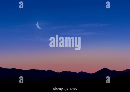 Quarter Moon Rising Over Desert Mountain Range, Arizona, USA Stock Photo