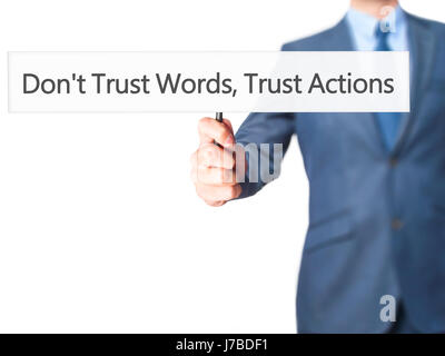 Don't Trust Words, Trust Actions - Businessman hand holding sign. Business, technology, internet concept. Stock Photo Stock Photo