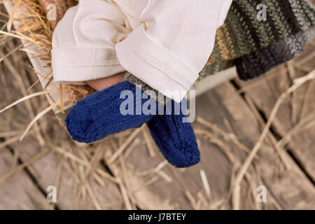 Baby legs in socks. Blue knitted wool. Dressing your baby for winter. Stock Photo