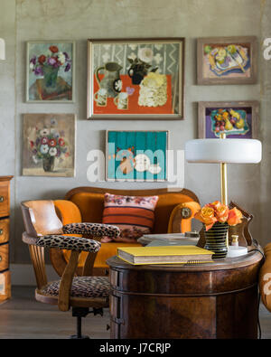 Leopard print chair at antique desk with framed artwork Stock Photo