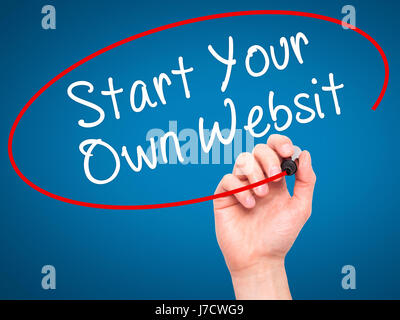 Man Hand writing Start Your Own Website with black marker on visual screen. Isolated on blue. Business, technology, internet concept. Stock Image Stock Photo