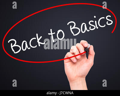 Man Hand writing Back to Basics black with marker on visual screen. Isolated on black. Business, technology, internet concept. Stock Image Stock Photo