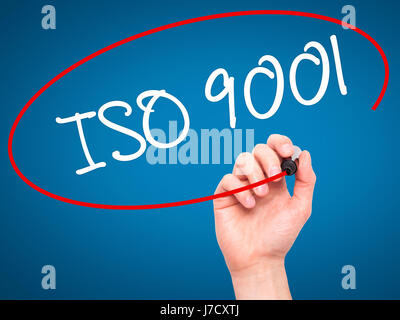 Man Hand writing  Iso 9001 with black marker on visual screen. Isolated on blue. Business, technology, internet concept. Stock Photo Stock Photo