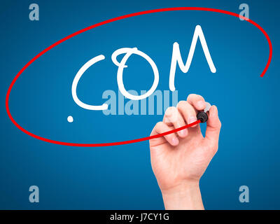 Man Hand writing .COM with black marker on visual screen. Isolated on blue. Business, technology, internet concept. Stock Image Stock Photo