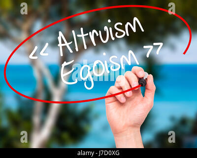 Man Hand writing Altruism - Egoism with black marker on visual screen. Isolated on background. Business, technology, internet concept. Stock Photo Stock Photo