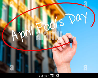 Man Hand writing April Fool's Day with black marker on visual screen. Isolated on city. Business, technology, internet concept. Stock Photo Stock Photo