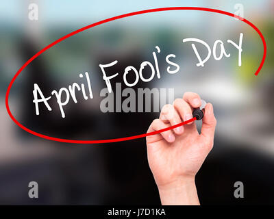 Man Hand writing April Fool's Day with black marker on visual screen. Isolated on office. Business, technology, internet concept. Stock Photo Stock Photo