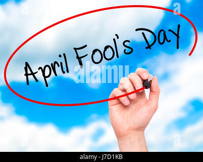 Man Hand writing April Fool's Day with black marker on visual screen. Isolated on sky. Business, technology, internet concept. Stock Photo Stock Photo