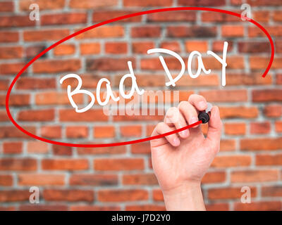 Man Hand writing Bad Day  with black marker on visual screen. Isolated on bricks. Business, technology, internet concept. Stock Photo Stock Photo