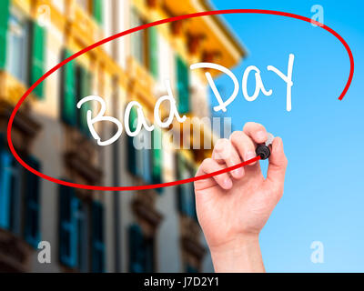Man Hand writing Bad Day  with black marker on visual screen. Isolated on city. Business, technology, internet concept. Stock Photo Stock Photo