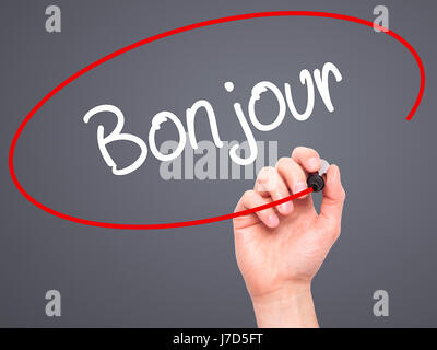 Man Hand writing Bonjour  (Good Morning in French) with black marker on visual screen. Isolated on background. Business, technology, internet concept. Stock Photo