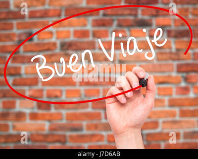 Man Hand writing Buen Viaje (Good Trip in Spanish) with black marker on visual screen. Isolated on bricks. Business, technology, internet concept. Sto Stock Photo