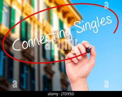 Man Hand writing Connecting Singles with black marker on visual screen. Isolated on city. Business, technology, internet concept. Stock Photo Stock Photo
