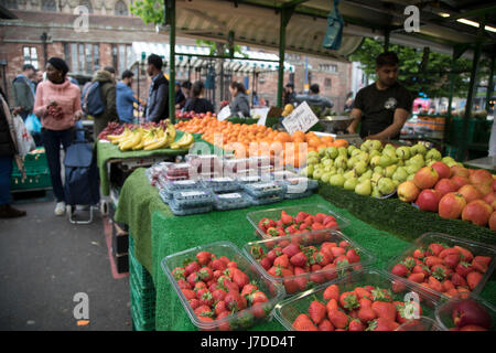 Multicultural scene at the Bullring Open Market, an outdoor food market in central Birmingham, United Kingdom. The Open Market offers a huge variety of fresh fruit and vegetables, fabrics, household items and seasonal goods. The Bull Ring Open Market has 130 stalls. Stock Photo
