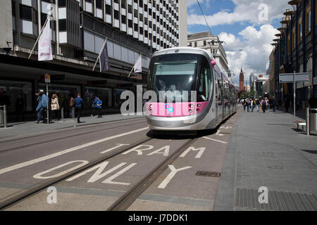 Midland Metro tram public transport system in central Birmingham, United Kingdom. The Midland Metro is a light-rail tram line in the county of West Midlands, England, operating between the cities of Birmingham and Wolverhampton via the towns of West Bromwich and Wednesbury. The line operates on streets in urban areas, and reopened conventional rail tracks that link the towns and cities. The owners are Transport for West Midlands with operation by National Express Midland Metro, a subsidiary of National Express. TfWM itself will operate the service from October 2018. Stock Photo