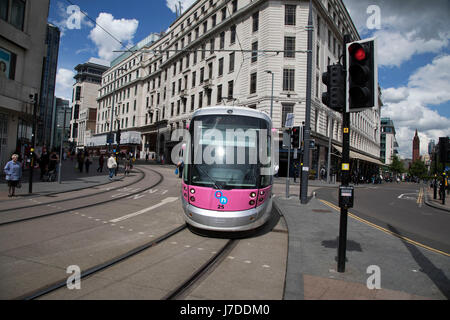 Midland Metro tram public transport system in central Birmingham, United Kingdom. The Midland Metro is a light-rail tram line in the county of West Midlands, England, operating between the cities of Birmingham and Wolverhampton via the towns of West Bromwich and Wednesbury. The line operates on streets in urban areas, and reopened conventional rail tracks that link the towns and cities. The owners are Transport for West Midlands with operation by National Express Midland Metro, a subsidiary of National Express. TfWM itself will operate the service from October 2018. Stock Photo