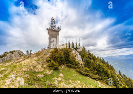 Telecommunication tower with satellite dishes and radio antennas on Postavaru peak, Poiana Brasov, Romania. Stock Photo