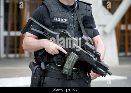 Armed police on patrol outside the Scottish Parliament building in Holyrood, Edinburgh, after Scotland Yard announced armed troops will be deployed to guard 'key locations' such as Buckingham Palace, Downing Street, the Palace of Westminster and embassies. Stock Photo