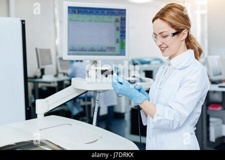 Positive delighted female testing new instrument Stock Photo