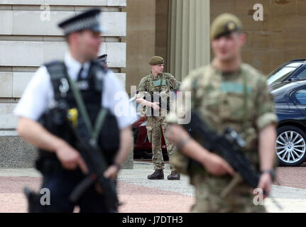 Members of the army join police officers outside Buckingham Palace, London, after Scotland Yard announced armed troops will be deployed to guard 'key locations' such as Buckingham Palace, Downing Street, the Palace of Westminster and embassies. Stock Photo