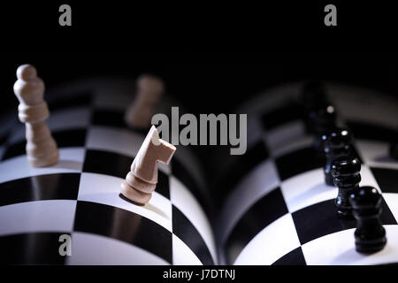 Chessman set in a row on salient chessboard on dark background Stock Photo