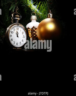 Vintage pocket watch hanging on Christmas tree near decorations Stock Photo