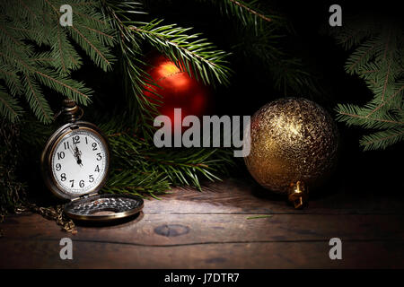 Christmas decoration. Vintage pocket watch on old wooden surface near fir twigs Stock Photo