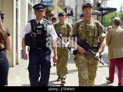 Members of the army join police officers on Whitehall, London, after Scotland Yard announced armed troops will be deployed to guard 'key locations' such as Buckingham Palace, Downing Street, the Palace of Westminster and embassies. Stock Photo